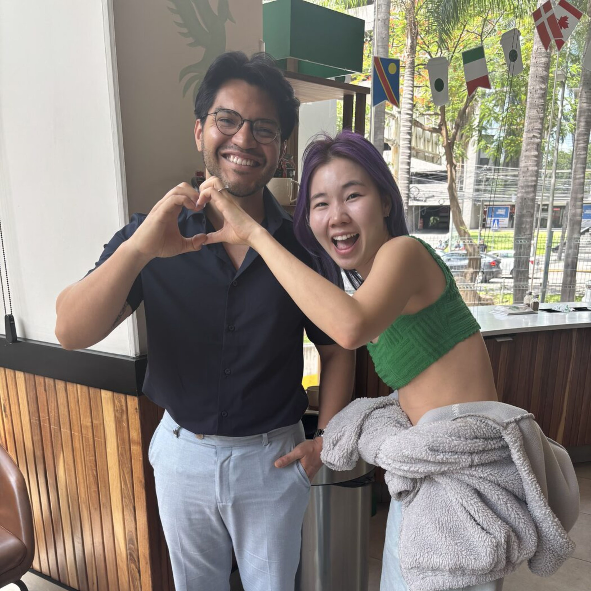Alberto Didu junto a una clienta celebrando con un gesto de corazón
